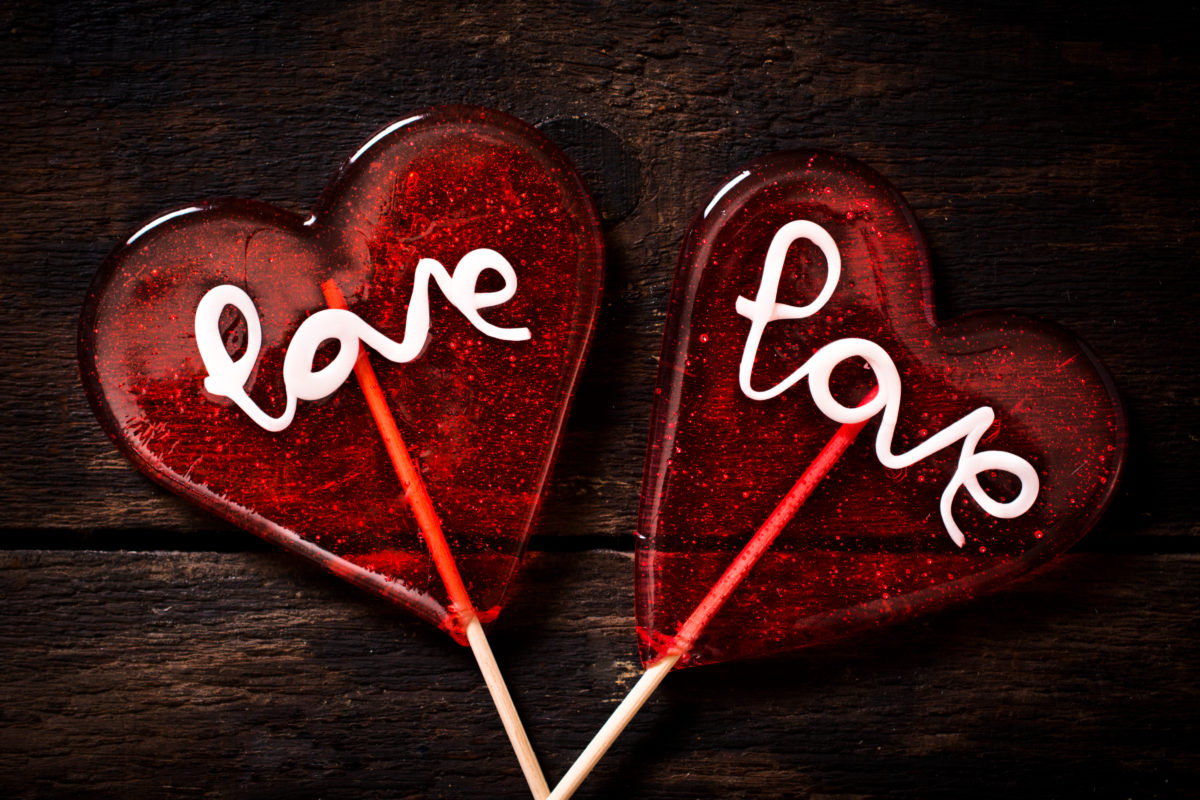 Love signs on the heart shape lolly pops on wooden background
