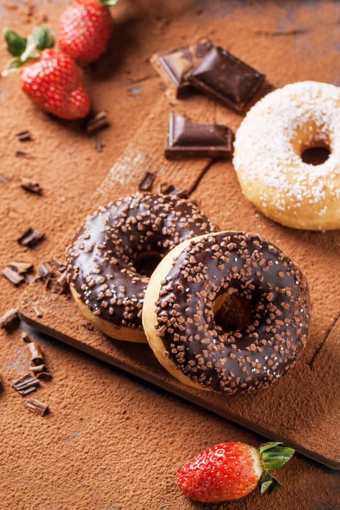 Chocolate dipped mini donuts with chopped chocolate on top.