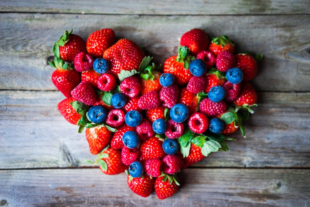 Strawberries, Blueberries, and Raspberries arranged into a heart shape.