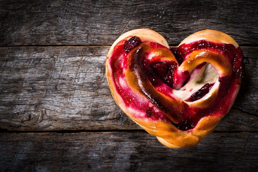 Heart-shaped Breakfast Pastry with red jam on top.