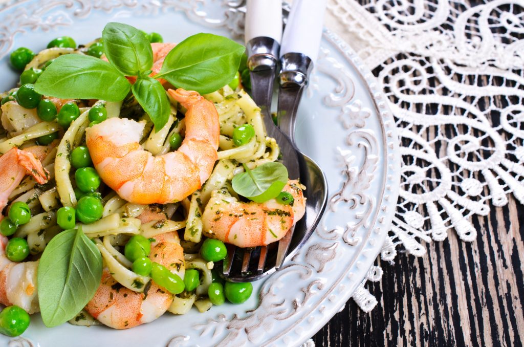 Pasta tagliatelle with shrimp and peas, dressed with pesto