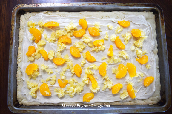 Layering crushed pineapple and Mandarin orange on top of The Ultimate Loaded Fruit Pizza