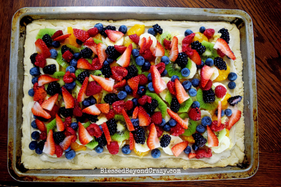 Layering fruit on top of The Ultimate Loaded Fruit Pizza