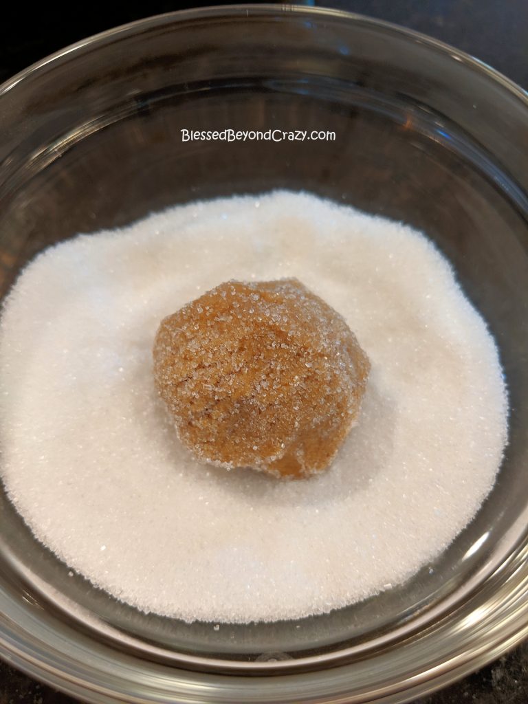 Rolling Ginger Snap Cookies in sugar