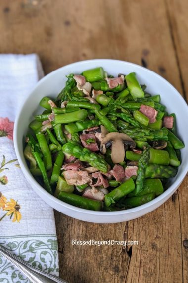 Bowl of cooked asparagus, bacon and mushrooms