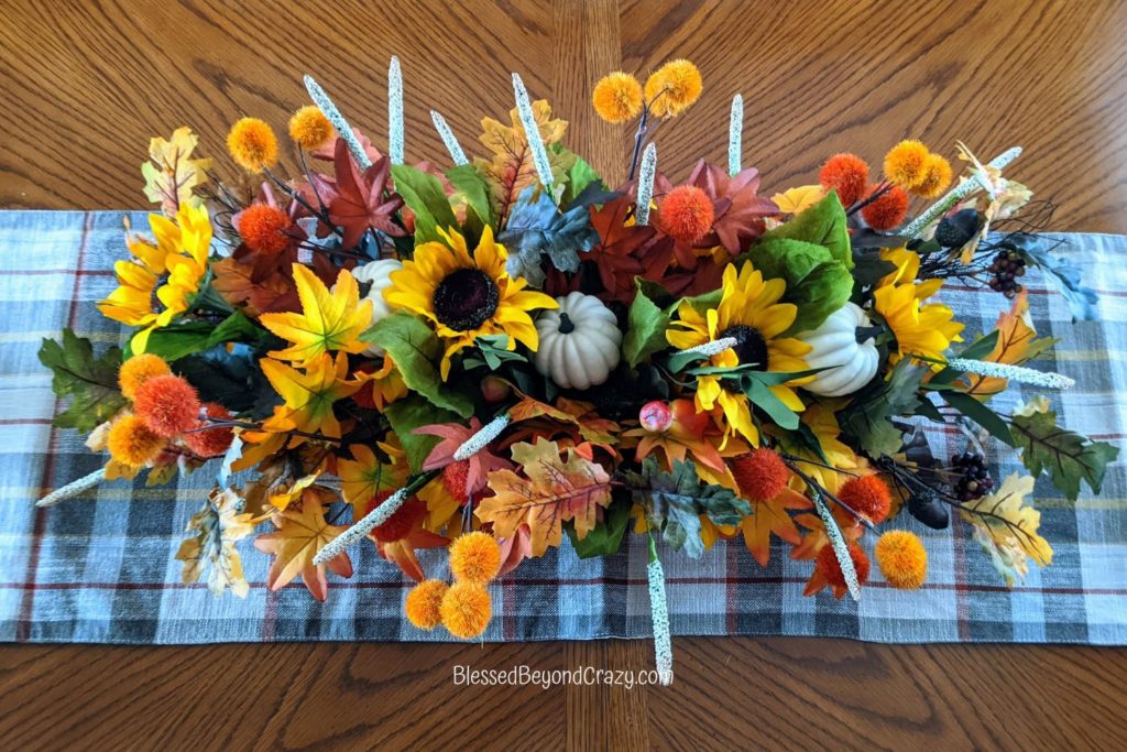 Overhead view of completed fall centerpiece on dining table.