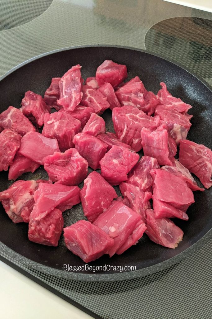 Chunks of beef in skillet ready to brown.