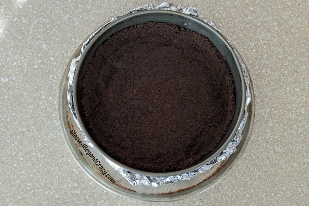 Overhead view of cookie crust pressed into the bottom and up the sides of a springform pan.