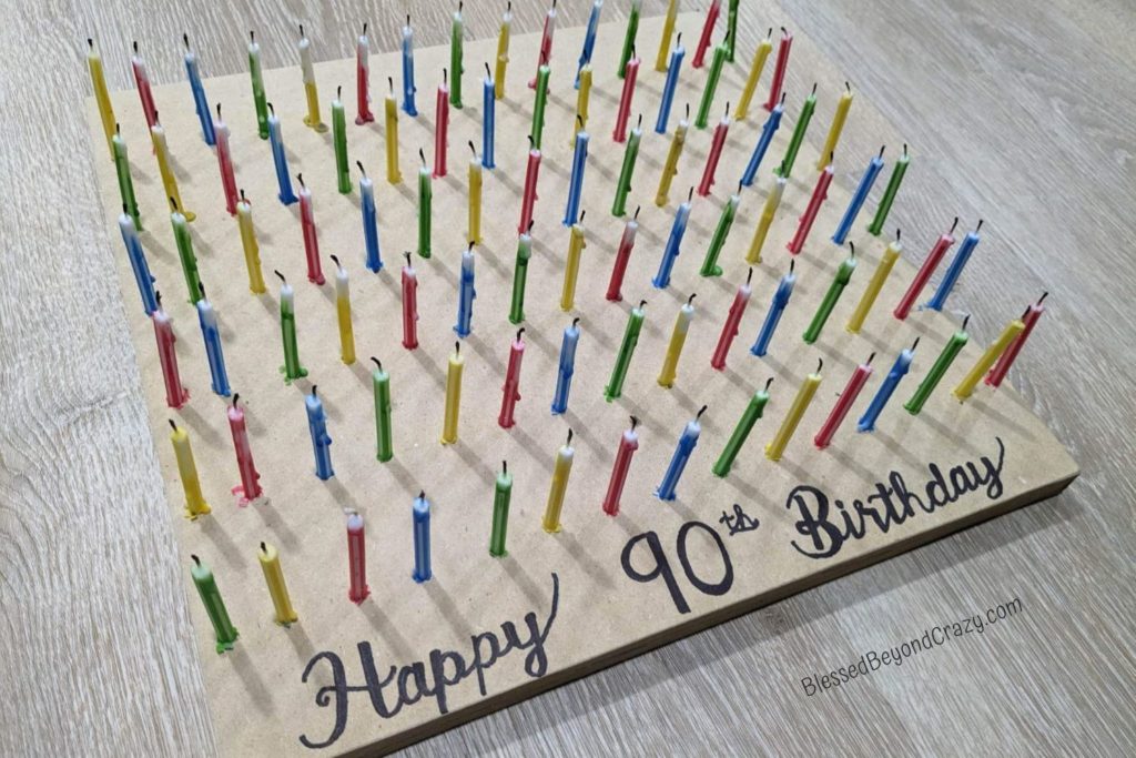 Homemade wooden candle holder with 90 birthday candles.