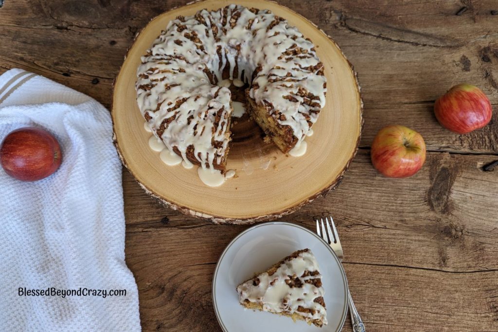 Overhead view of apple streusel cake with one piece cut out and placed on a dessert plate.