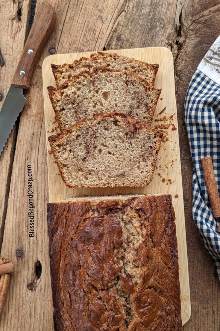 Overhead view of a loaf of cinnamon swirl coffee cake with three cut pieces