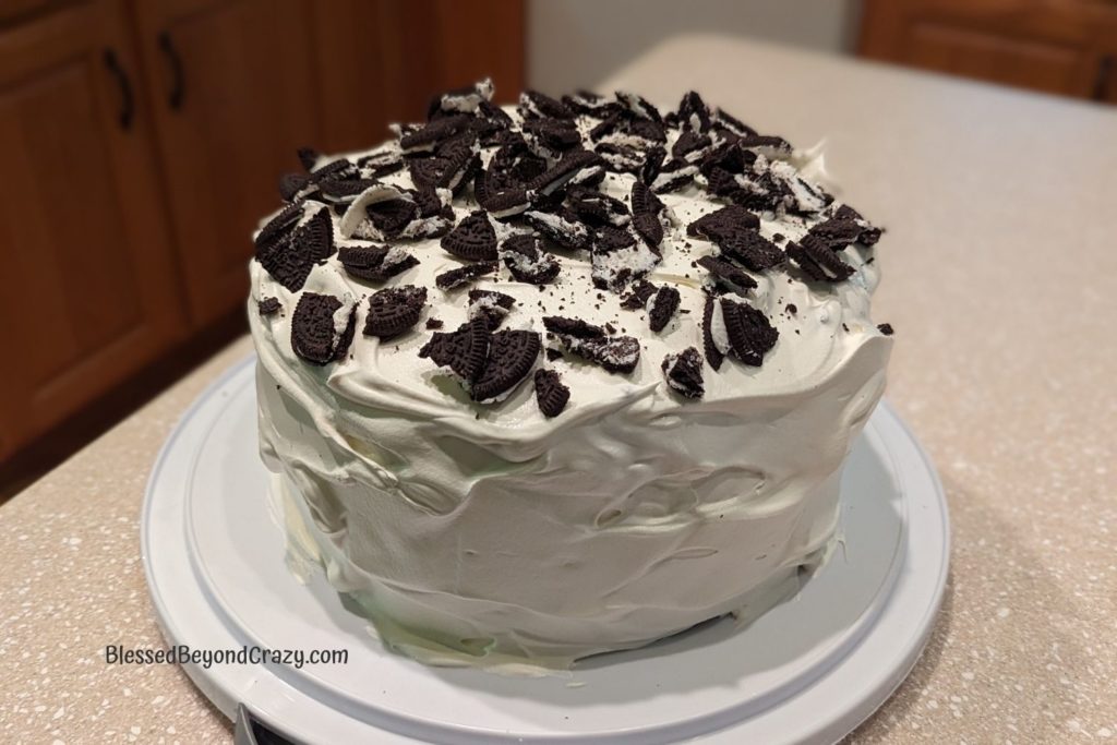 Overhead view of crushed Oreo cookies on top of 4-Layer Gluten-Free Oreo Ice Cream Cake.
