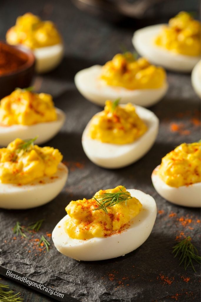 Deviled eggs ready to eat on slate platter.