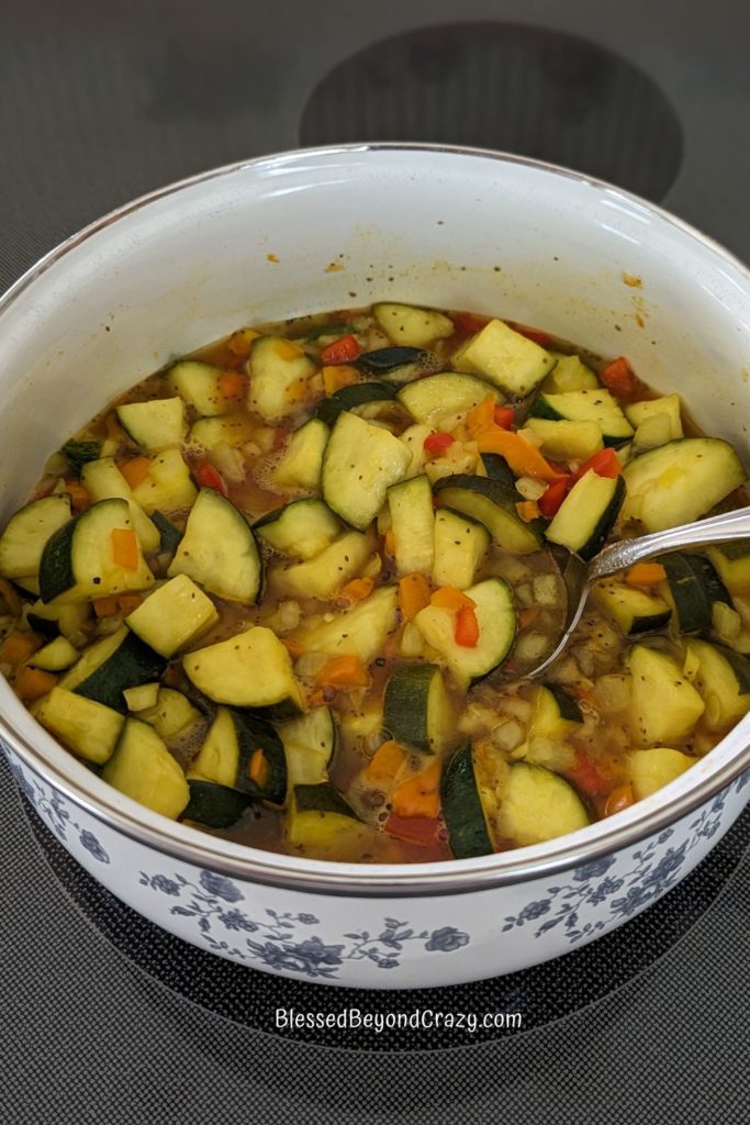 Saucepan with zucchini relish cooking on stovetop.