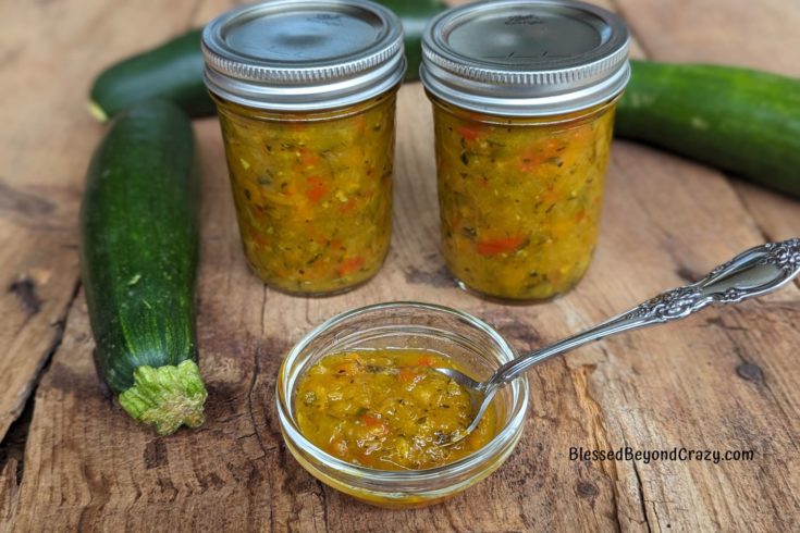 Freshly made zucchini relish in small bowl and half-pint canning jars.