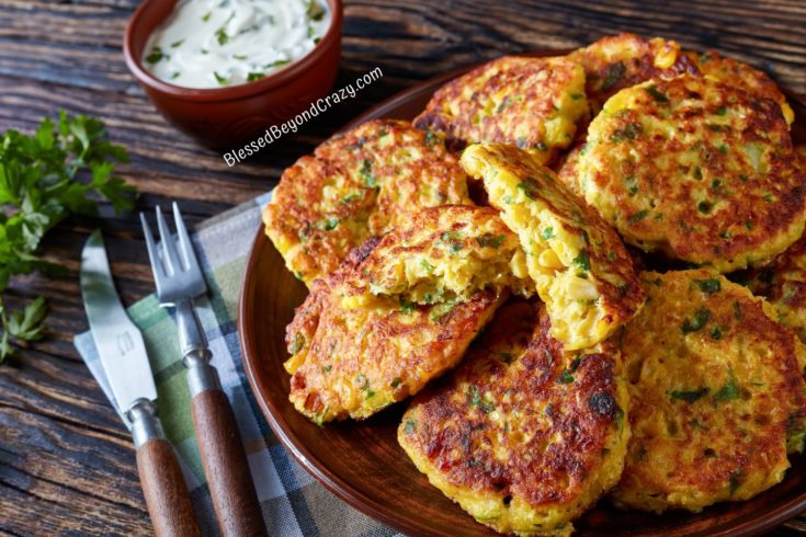 Sweet Corn Fritters on a plate with one cut in half.