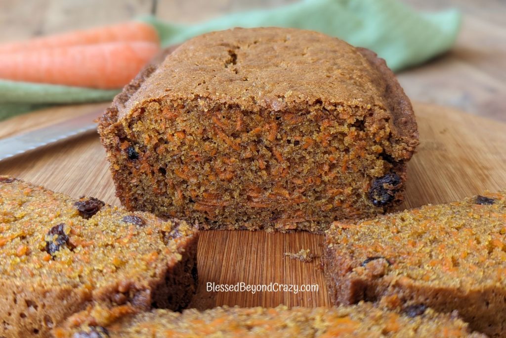 Side view of sliced carrot bread where you can easily see the shredded carrots and raisins in the loaf.
