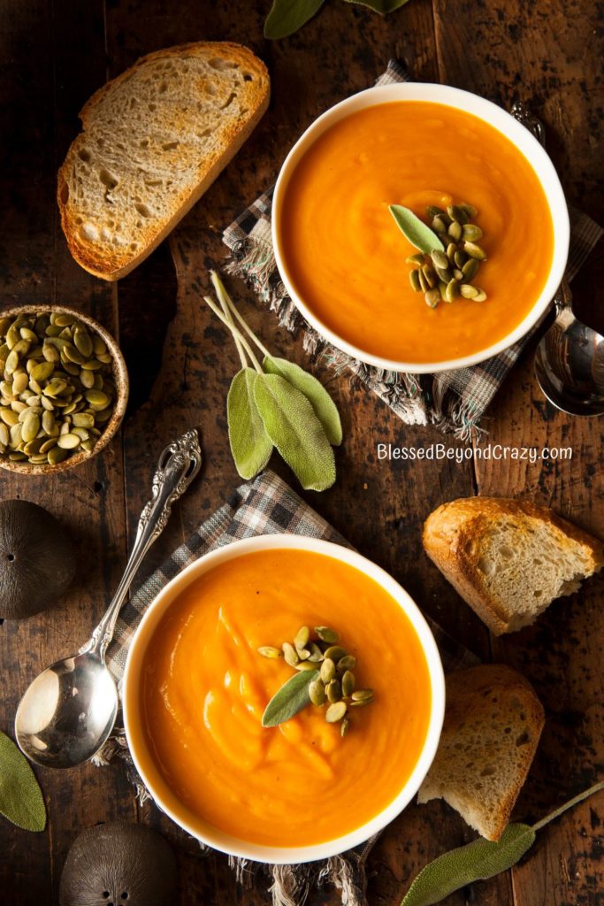 Overhead view of two bowls of butternut squash soup.