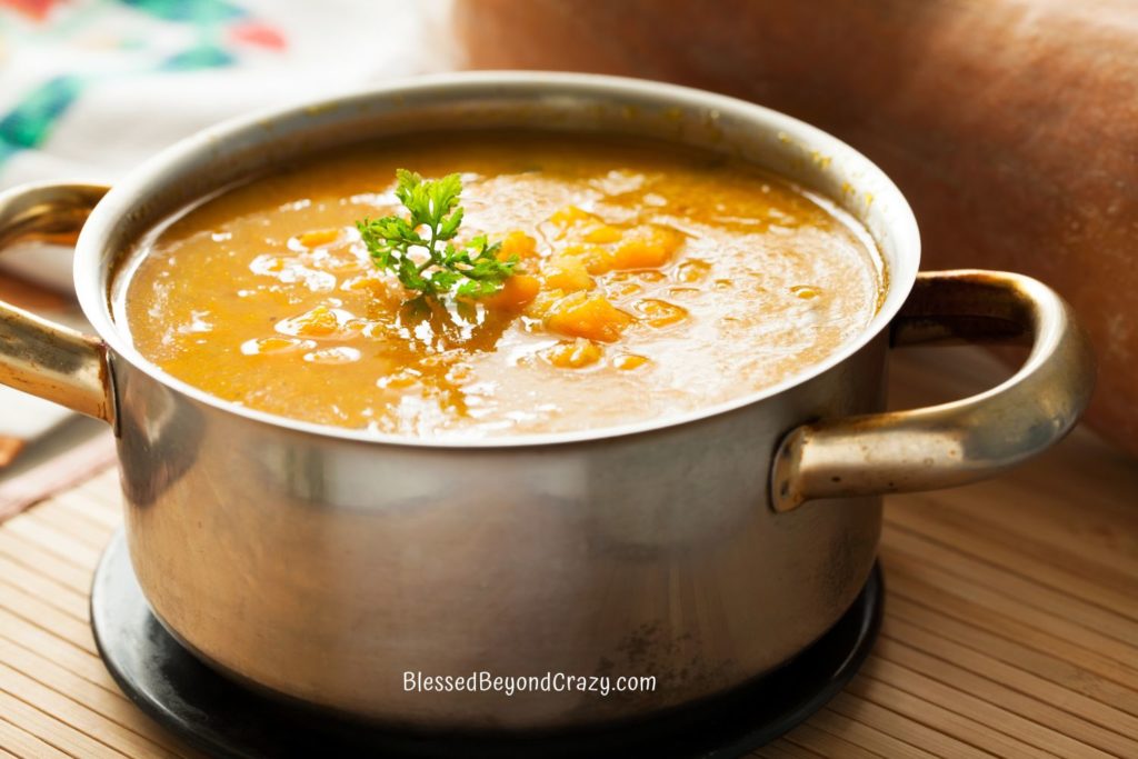 Pot of soup with sprig of fresh parsley.