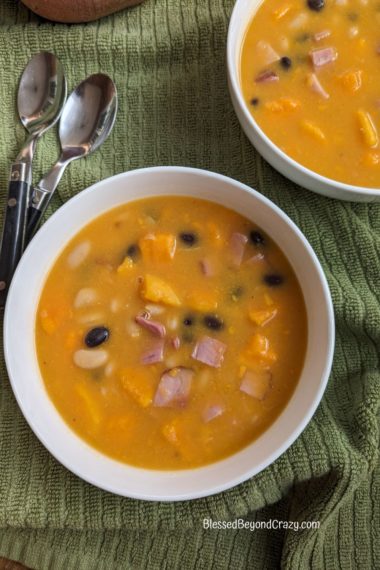 Overhead view of white bowls of Ham, Sweet Potato and Bean soup
