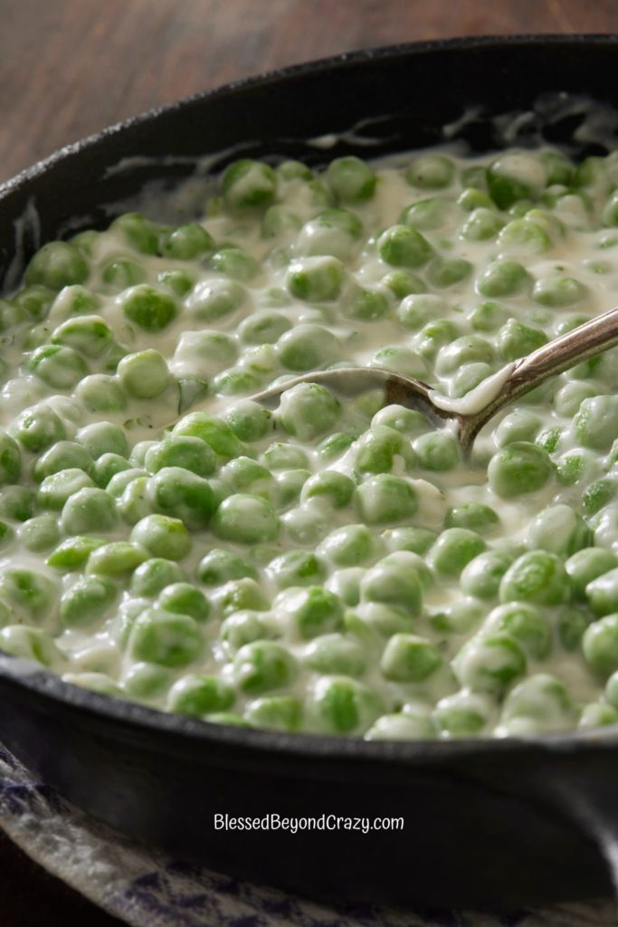 Vertical photo of skillet of creamed peas.