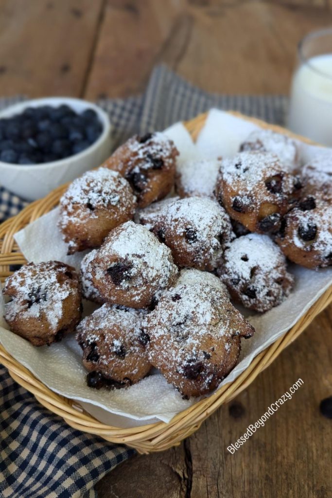 Basket full of freshly fried blueberry fritters.