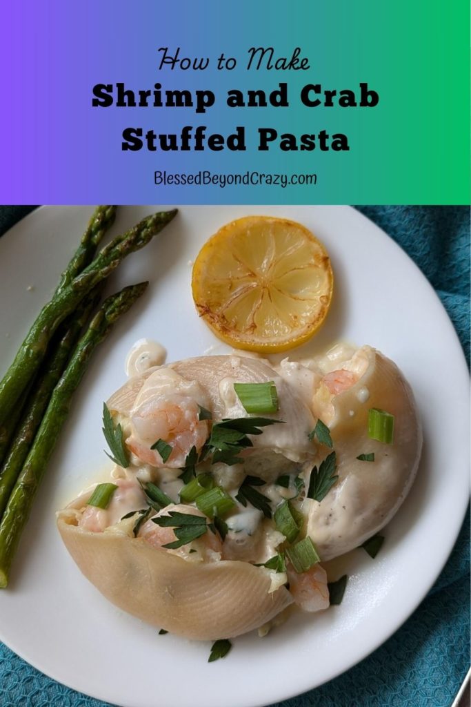 Pinterest image of Shrimp and Crab Stuffed Pasta on a white plate with asparagus and slice of lemon.