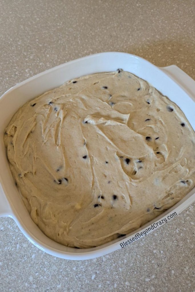 Overhead photo of chocolate chip batter in glass baking dish, ready to bake.