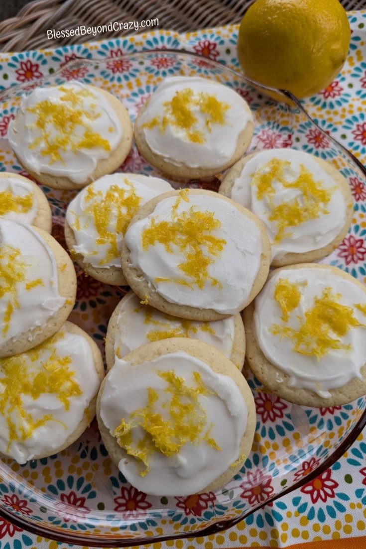 Overhead photo of plate of lemon cookies with fresh lemon in background.