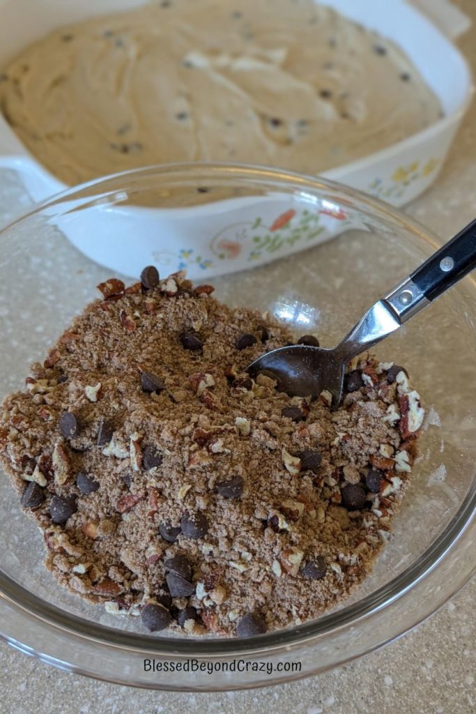 Glass bowl with streusel topping ready to sprinkle on top of coffee cake batter.