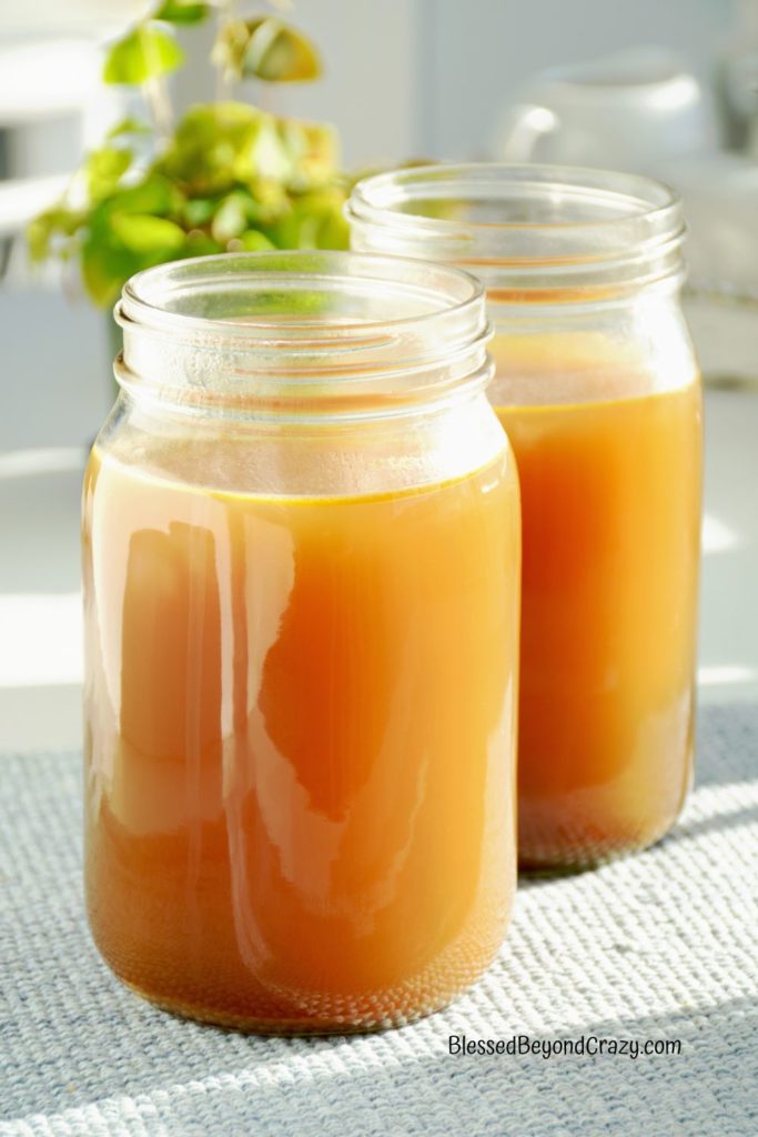 Photo of two jars of fresh chicken broth.