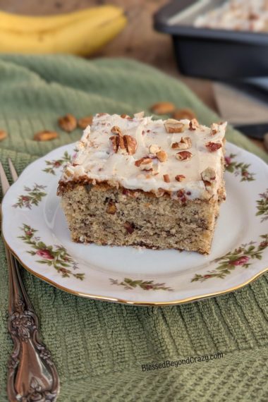 Photo of one serving of banana pecan cake on a pretty China dessert plate.