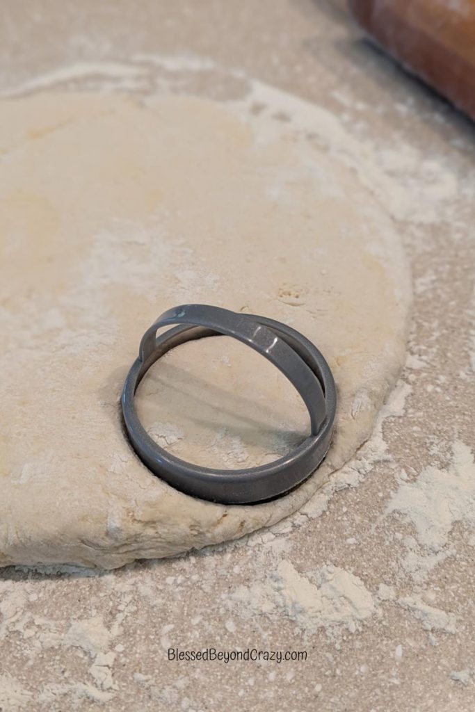 Biscuit cutter on top of rolled out biscuit dough.