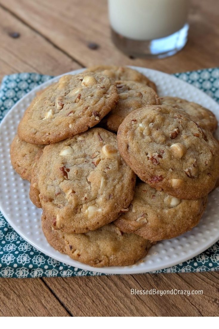 White dessert plate with stack of White Chocolate Pecan cookies on it.