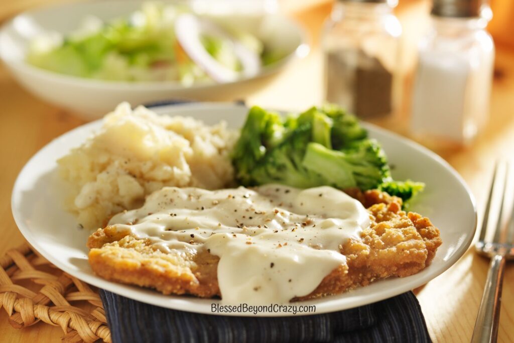 Vertical photo of of ready to eat chicken fried steak, broccoli, and potatoes.